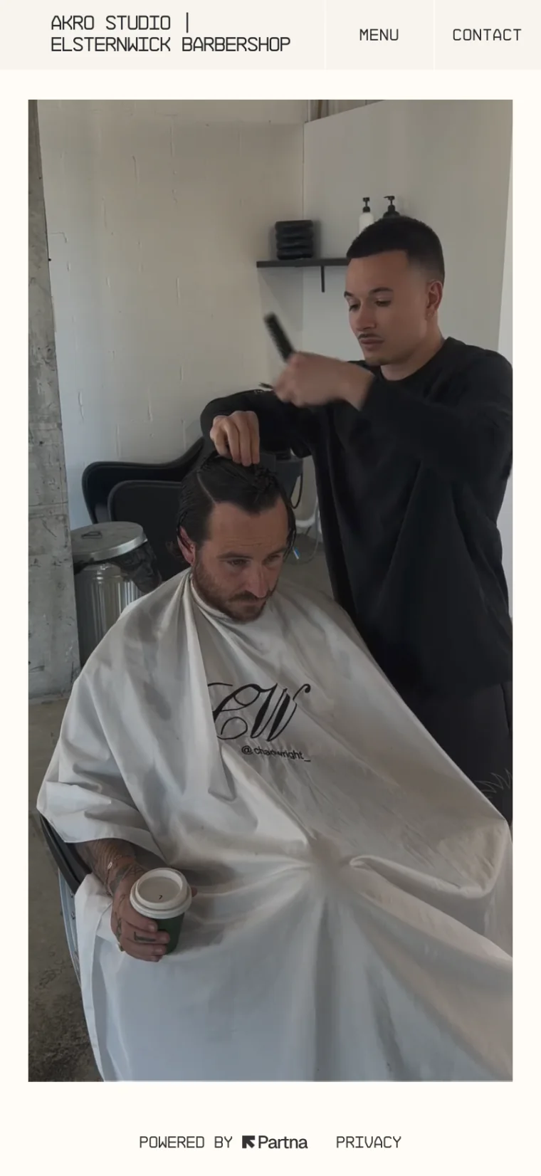 A phone showing a barbershop's Milkcrate site: its name in a mono typeface above a photo